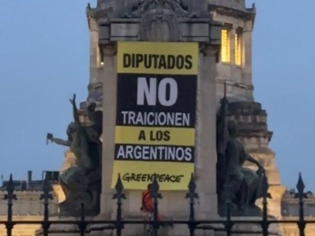 Activistas de Greenpeace treparon a un monumento frente al Congreso con banderas contra la modificación de la Ley de Glaciares